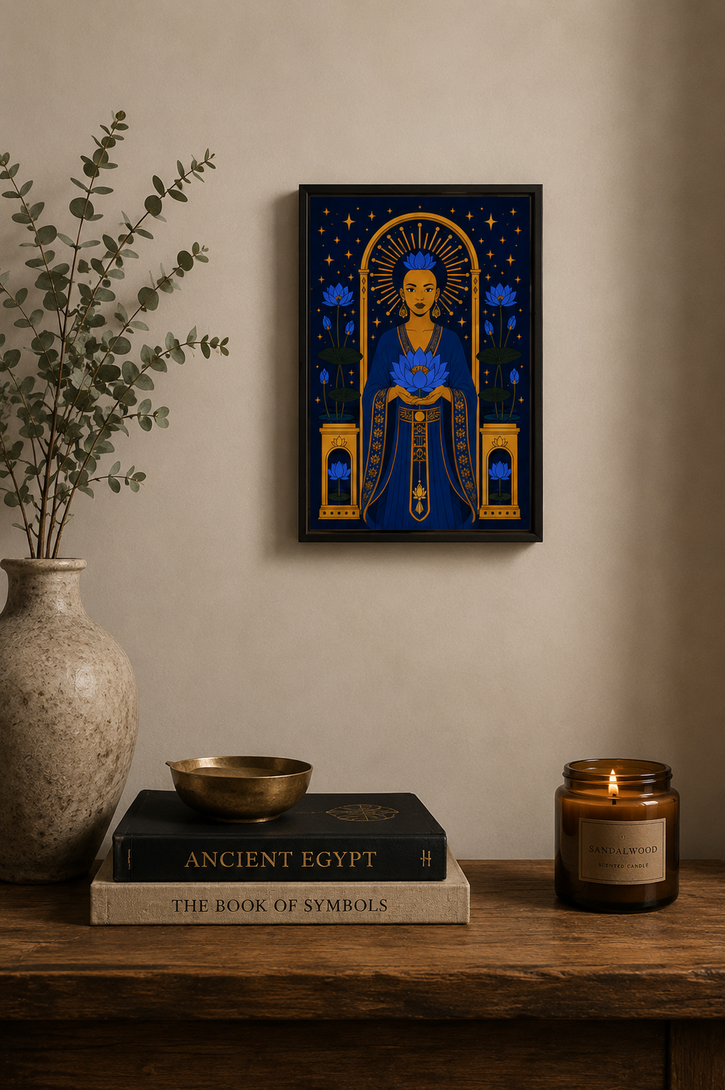 Framed artwork of a woman with a blue robe on a wooden shelf with books and a candle.